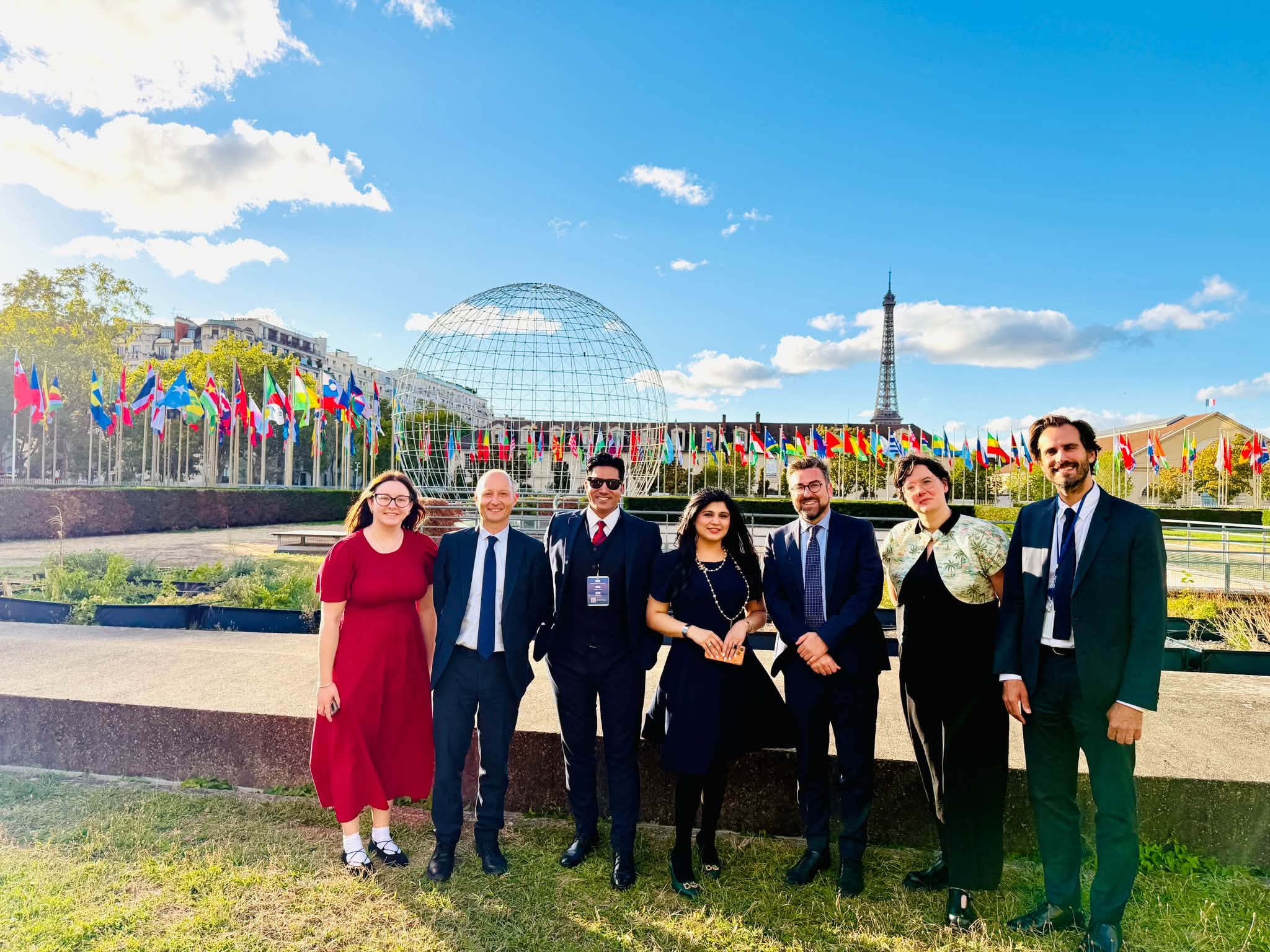 Rizwan Anwar with Paul Waugh MP and the British delegation at UNESCO Headquarters in Paris, with the Eiffel Tower behind